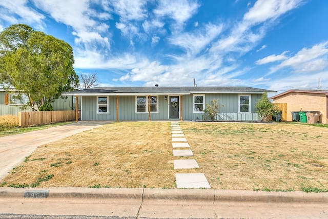 ranch-style house with fence and a front lawn