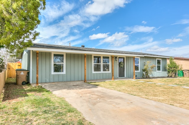 ranch-style house with a front lawn, board and batten siding, and fence