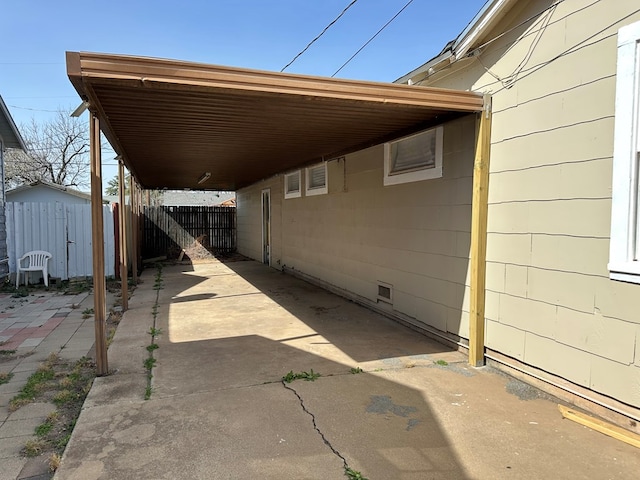 exterior space with an attached carport, fence, and driveway