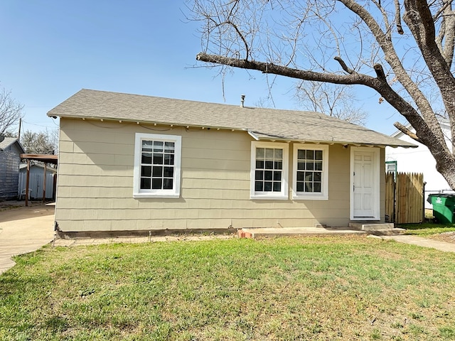 ranch-style house with a front yard, concrete driveway, and fence