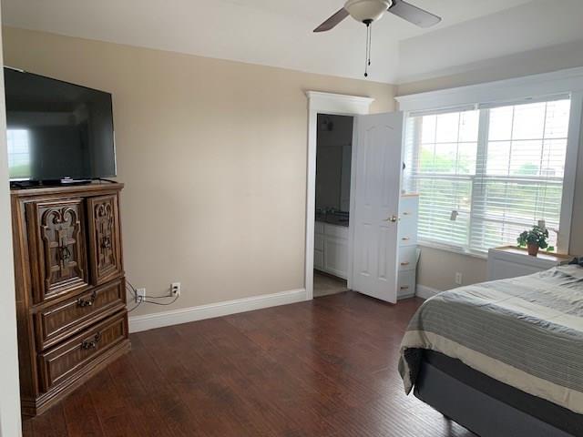 bedroom featuring ceiling fan, connected bathroom, and dark hardwood / wood-style flooring