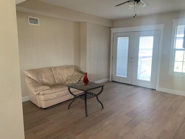 living room featuring hardwood / wood-style floors, french doors, and ceiling fan