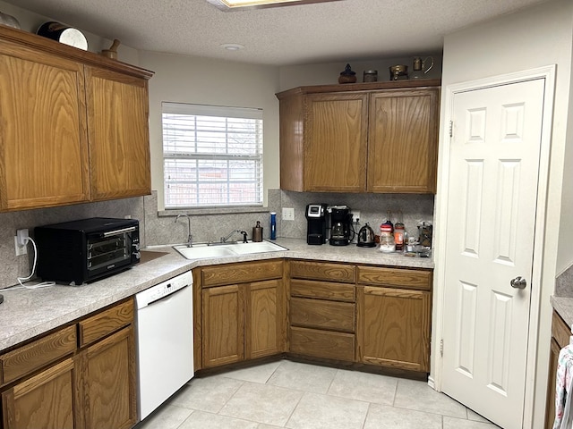 3570 Grandview Dr, San Angelo, TX 76904 - kitchen with white dishwasher, tasteful backsplash, brown cabinetry, light tile patterned floors, and light countertops