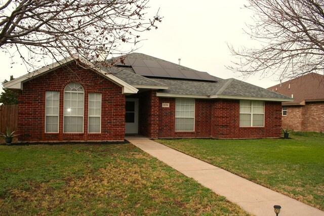 3570 Grandview Dr, San Angelo, TX 76904 - single story home with brick siding, solar panels, a front lawn, and a shingled roof