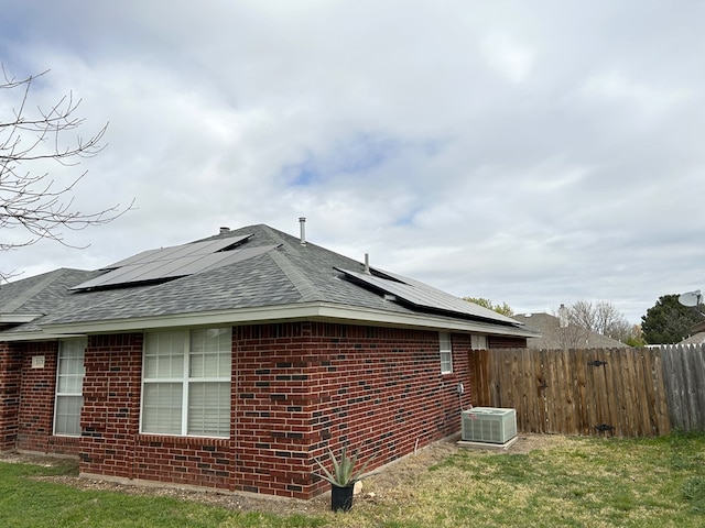 3570 Grandview Dr, San Angelo, TX 76904 - view of property exterior with a shingled roof, brick siding, and solar panels