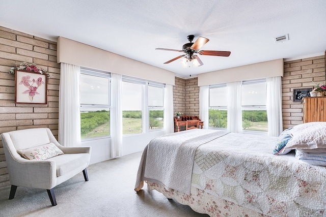 6290 Stokes Rd, San Angelo, TX 76904 - bedroom with brick wall, carpet flooring, multiple windows, and a ceiling fan