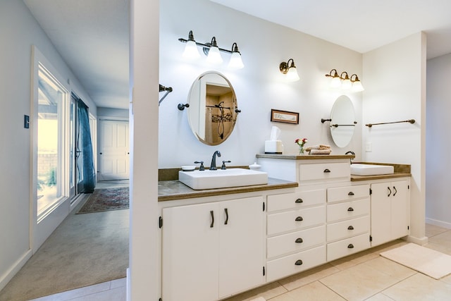 6290 Stokes Rd, San Angelo, TX 76904 - full bath with double vanity, tile patterned floors, and baseboards