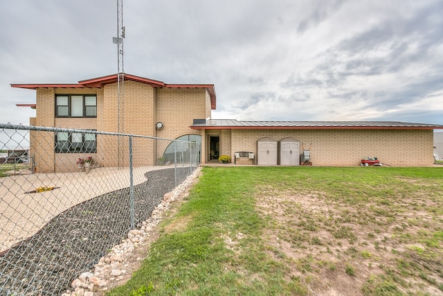 6290 Stokes Rd, San Angelo, TX 76904 - rear view of house featuring brick siding, a shed, a standing seam roof, and an outbuilding