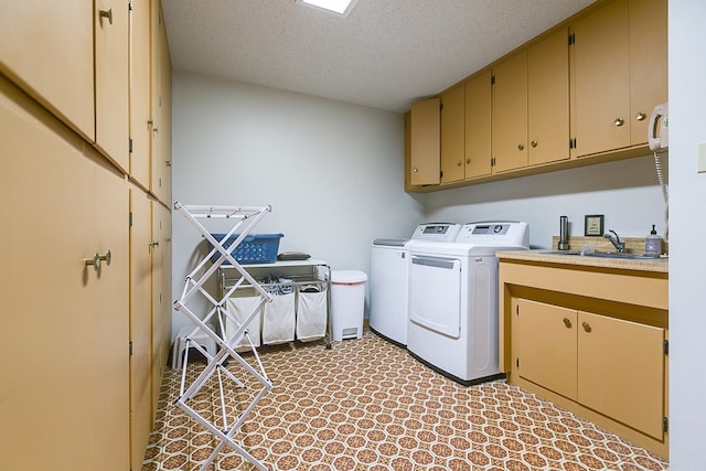 6290 Stokes Rd, San Angelo, TX 76904 - laundry area featuring washing machine and clothes dryer, cabinet space, and a textured ceiling