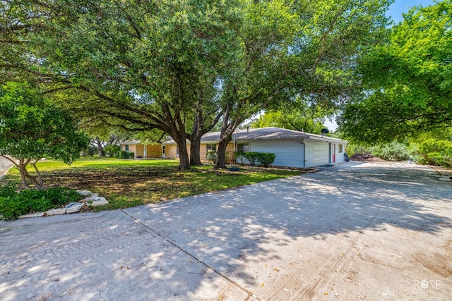 single story home with a garage and a front lawn