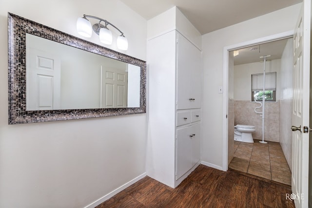 bathroom featuring tile walls, wood-type flooring, and toilet