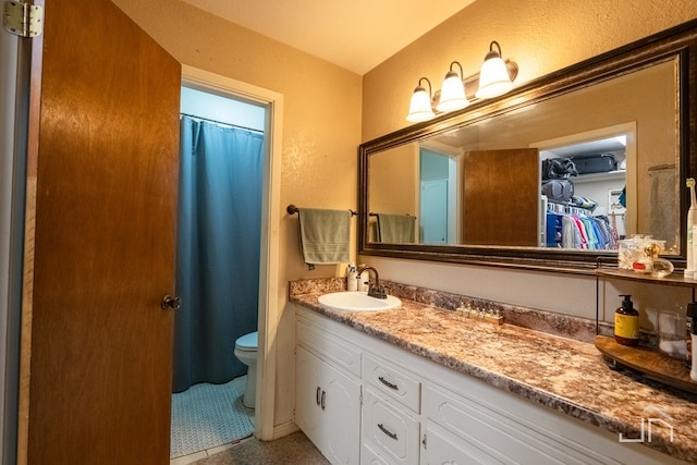 bathroom with walk in shower, tile patterned floors, vanity, and toilet