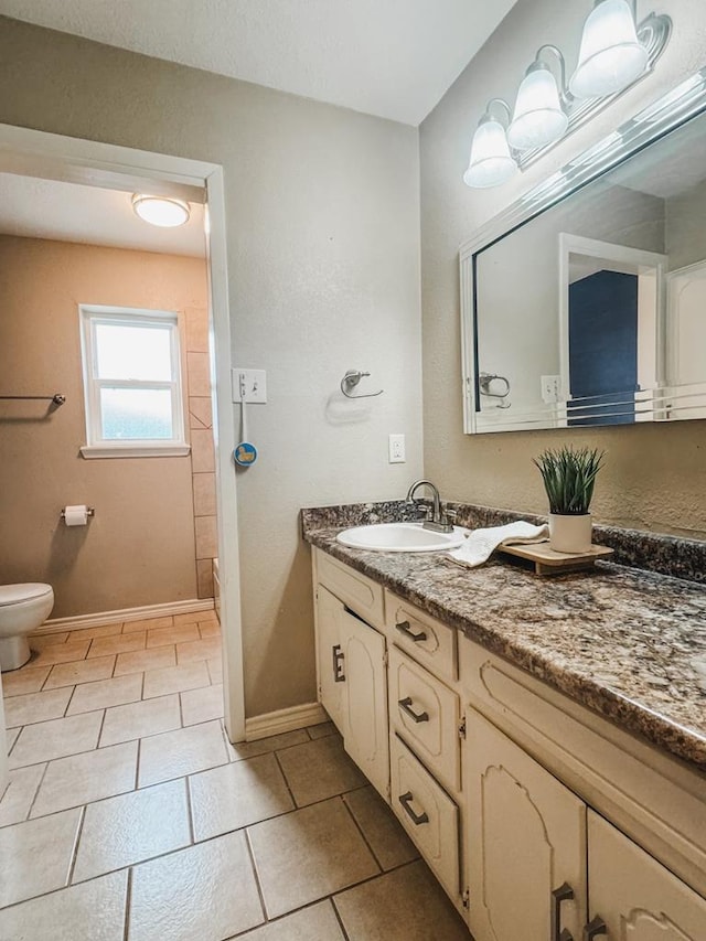 bathroom with vanity, tile patterned floors, and toilet