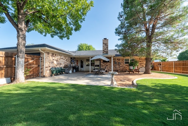 back of property featuring a patio and a yard