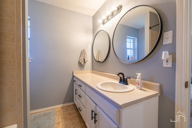 full bath with tile patterned floors, baseboards, a shower, and vanity