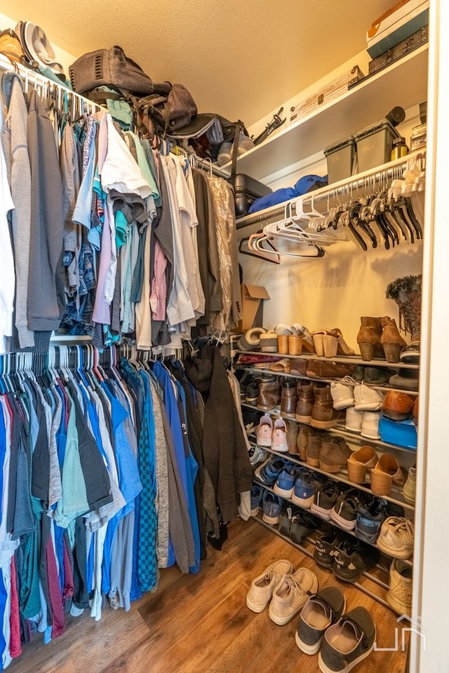 walk in closet with wood finished floors