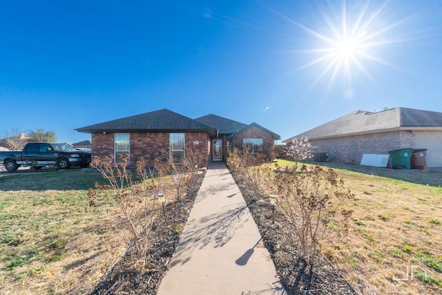 ranch-style home with brick siding and a front yard