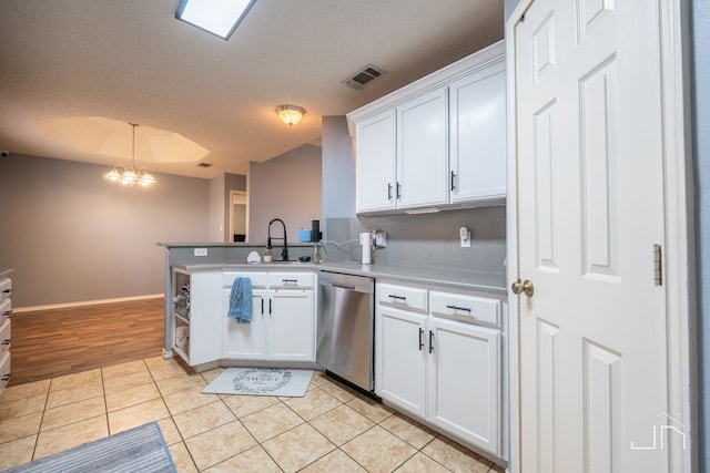 kitchen with visible vents, dishwasher, light tile patterned floors, white cabinets, and a sink