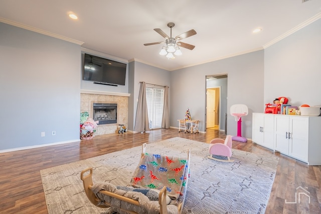 game room featuring wood finished floors, baseboards, and a tile fireplace