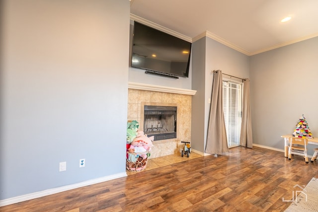 unfurnished living room with baseboards, ornamental molding, recessed lighting, a fireplace, and wood finished floors