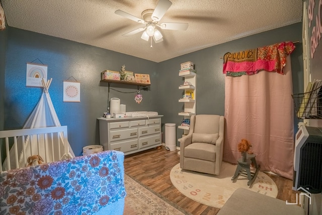 bedroom featuring a textured ceiling, wood finished floors, and a ceiling fan