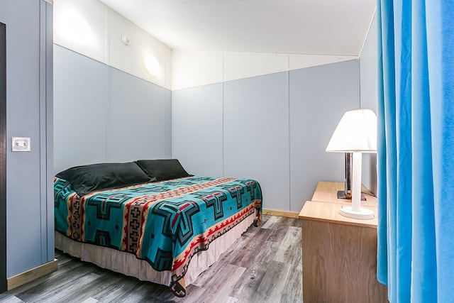 bedroom with hardwood / wood-style flooring and vaulted ceiling