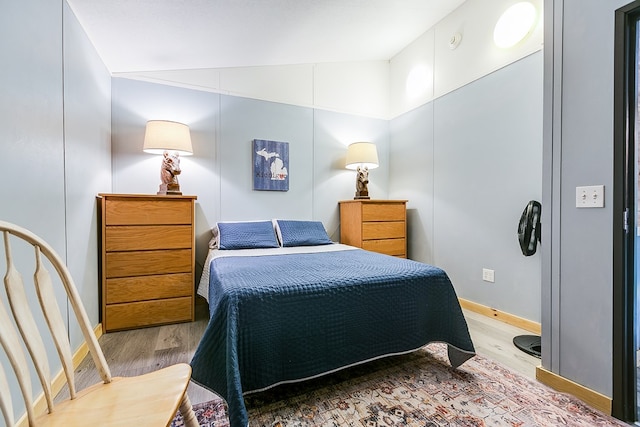 bedroom featuring vaulted ceiling and light hardwood / wood-style floors