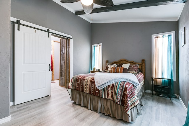 bedroom with vaulted ceiling with beams, light hardwood / wood-style flooring, ornamental molding, ceiling fan, and a barn door