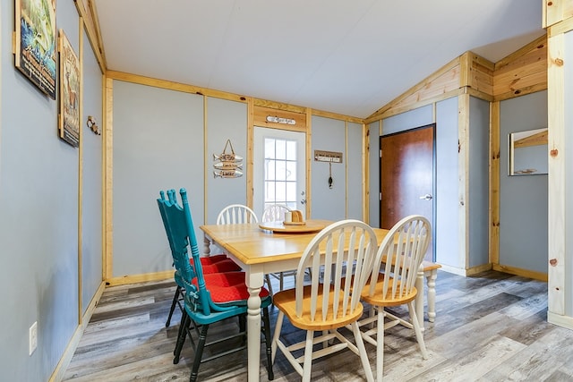 dining space featuring light hardwood / wood-style flooring and vaulted ceiling