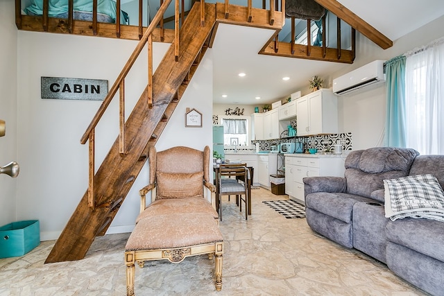 living room with a high ceiling and an AC wall unit