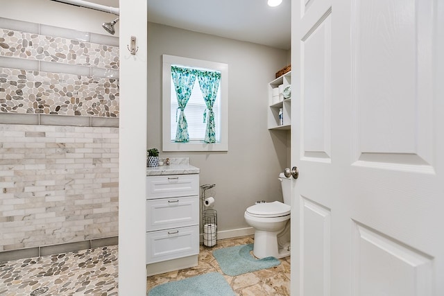 bathroom with vanity, toilet, and brick wall