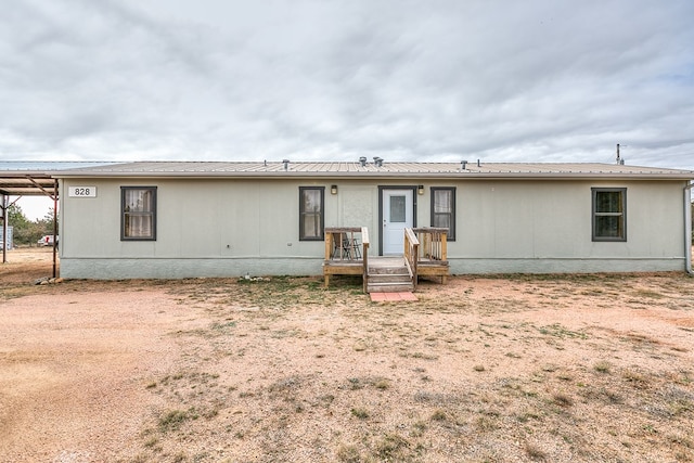 rear view of property featuring a wooden deck