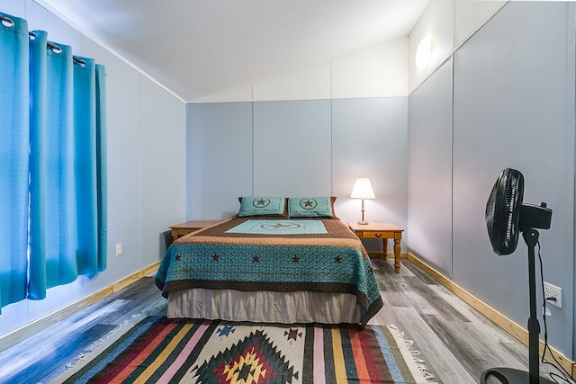 bedroom featuring hardwood / wood-style flooring and lofted ceiling