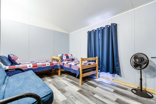 bedroom with wood-type flooring and lofted ceiling