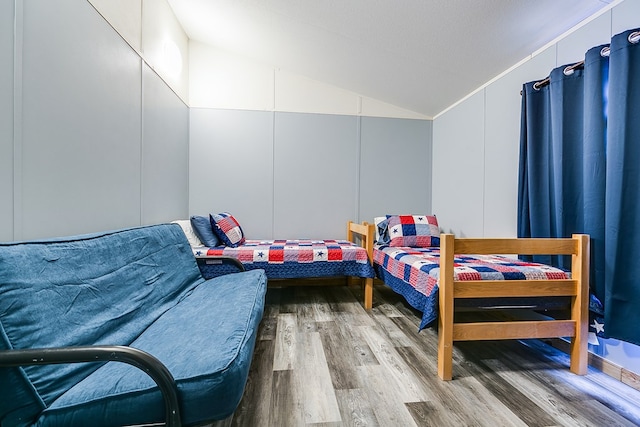 bedroom with vaulted ceiling and wood-type flooring