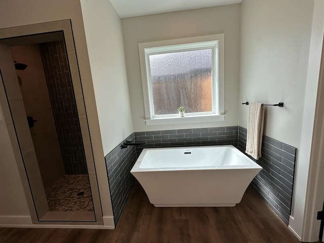 3611 Clearview Dr, San Angelo, TX 76904 - full bathroom with a freestanding tub, wood finished floors, tile walls, a stall shower, and wainscoting