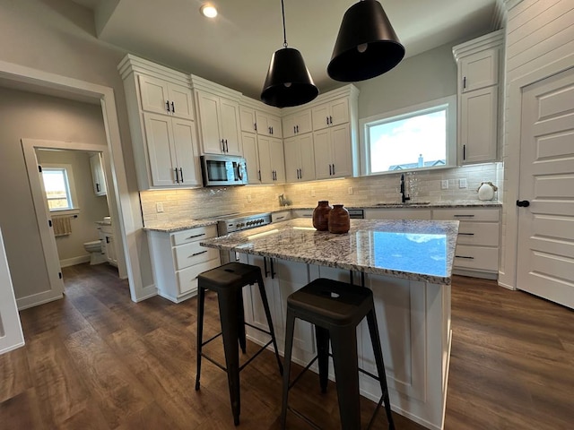 3611 Clearview Dr, San Angelo, TX 76904 - kitchen with stainless steel microwave, backsplash, and white cabinetry