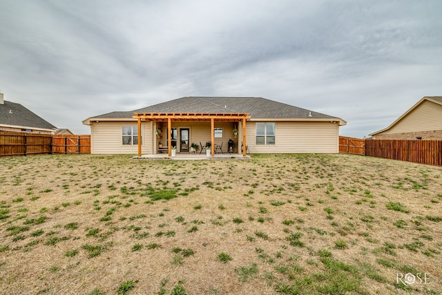 rear view of house featuring a patio and a fenced backyard