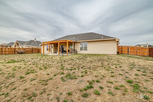 back of property featuring a patio area, a yard, and a fenced backyard