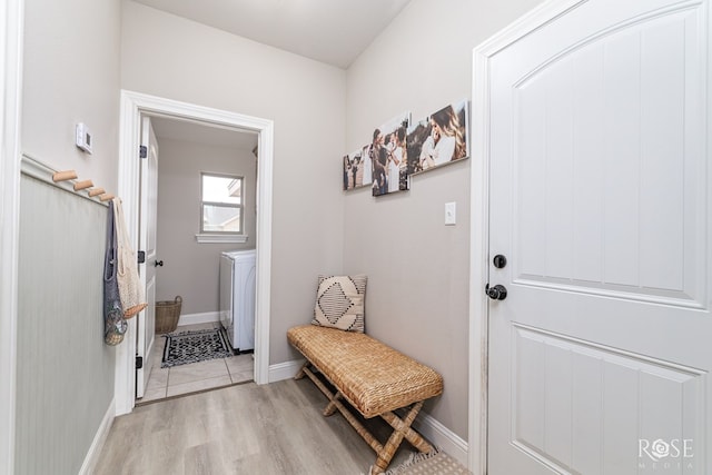 mudroom featuring washer / clothes dryer, baseboards, and light wood-type flooring