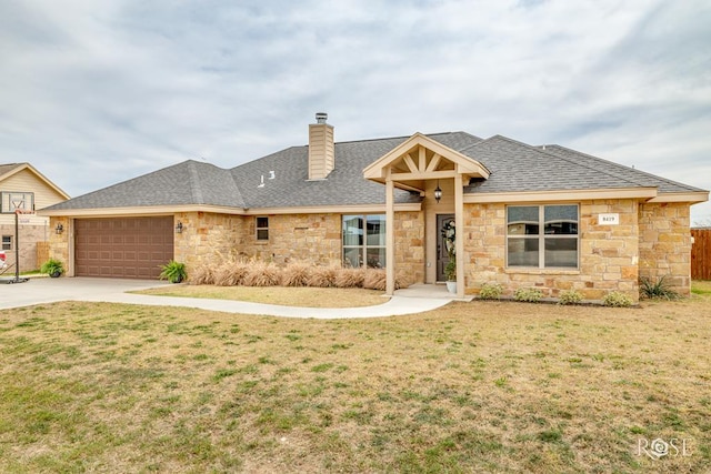 single story home featuring a front yard, an attached garage, stone siding, and a shingled roof