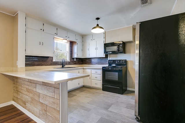 kitchen with black appliances, sink, white cabinets, hanging light fixtures, and kitchen peninsula