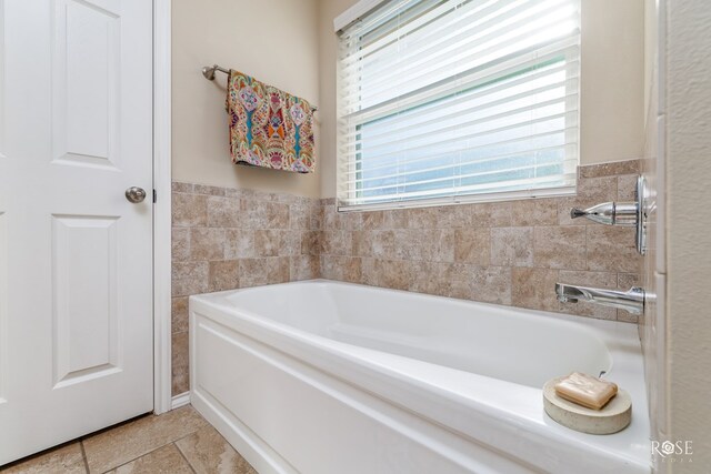 bathroom featuring a bathing tub, tile walls, and tile patterned floors