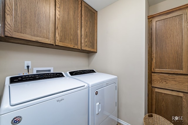 laundry room with cabinets and washing machine and clothes dryer