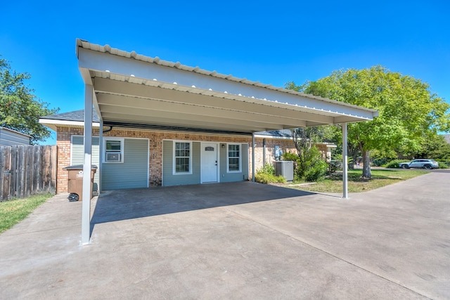 view of front of house with a carport and central AC unit