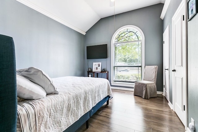 bedroom with vaulted ceiling, dark wood-type flooring, and ceiling fan