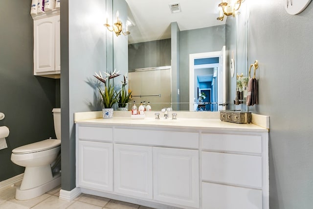 bathroom featuring tile patterned floors, toilet, an enclosed shower, and vanity