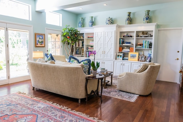 sitting room with a healthy amount of sunlight, dark hardwood / wood-style flooring, and a high ceiling