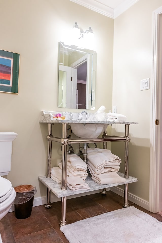 bathroom with ornamental molding and toilet