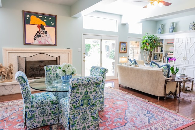 dining area with ceiling fan, a high end fireplace, and wood-type flooring